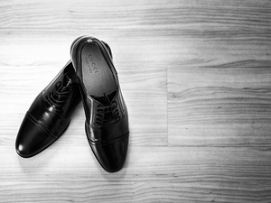 alt=Groom getting ready in elegant schoes for a destination wedding in Italy