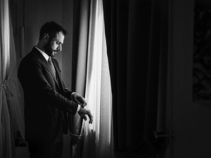 alt=Groom getting ready in elegant attire for a destination wedding in Italy