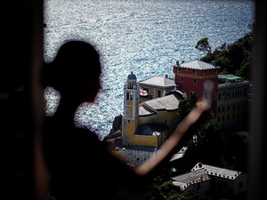 alt=Happy bride in front of the window at Castello Brown in Portofino during Irida and Steven's destination wedding