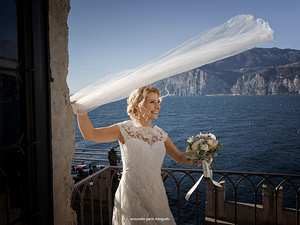 alt=la sposa con vista lago dal castello di malcesine lago di garda