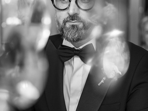 alt=lo sposo si prepara davanti alla finesta di fronte al lago di garda