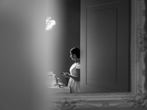 alt=la sposa alla finestra mentre guarda il lago di garda