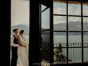 sposi abbracciati guardano il lago di garda a malcesine surante il servizio fotografico di matrimonio