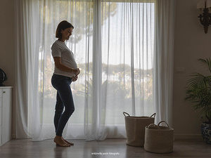Fotografia di maternità a casa in ambiente familiare con luce naturale