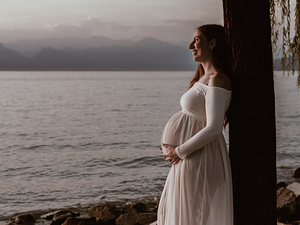 Ritratto maternità in esterni con luce morbida e paesaggio naturale