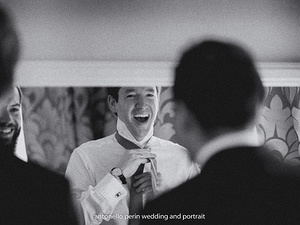 sposo davanti allo specchio mentre indossa l'abito prima del matrimonio