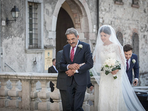 alt=The bride enters the church before the ceremony alongside her father