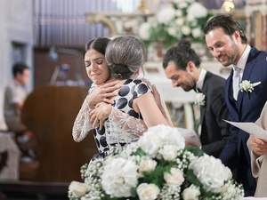alt=The bride hugs the maid of honor at the wedding