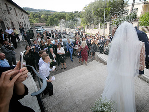 alt=The newlyweds leave the church after the wedding ceremony on Lake Garda