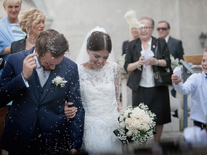 alt=throwing rice as the couple exits the church after the wedding