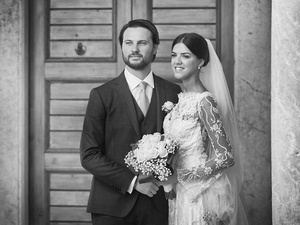 alt=the newlyweds outside the church for a professional portrait with the photographer