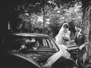 alt=The newlyweds get out of the car at the venue