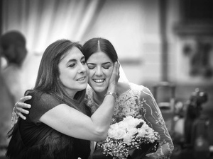 alt=intimate hug between the bride and her aunt at the wedding reception on Lake Garda