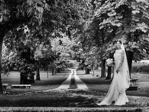 alt=The bride poses for the professional photo shoot in the park of Villa Mosconi Bertani
