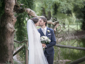 alt=the newlyweds in front of the pond at Villa Mosconi Bertani, Lake Garda