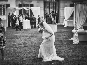 alt=the bride alone at the garden reception with white gazebos at Villa Mosconi Bertani
