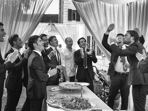alt=the groom with friends in front of the refreshment table on Lake Garda