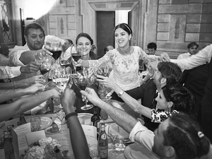alt=The bride toasts with her friends at the wedding reception on Lake Garda